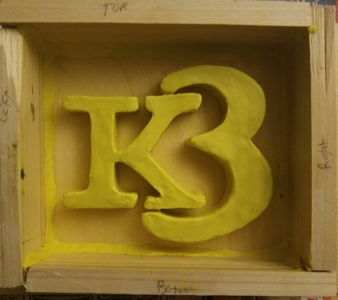 clay logo in wooden form frame