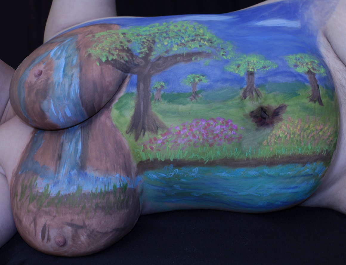 Painted female torso, laying on her side: left-to-right: waterfall over breasts to forest and tree glen with a river