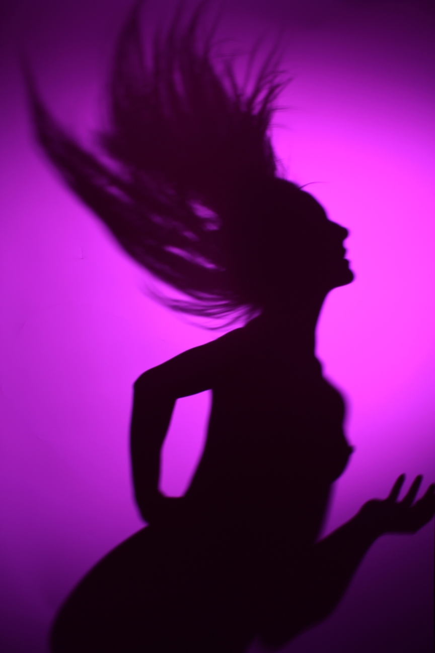 nude model in silhouette against a purple background