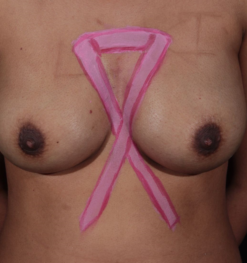 painting of pink ribbon on chest of female nude