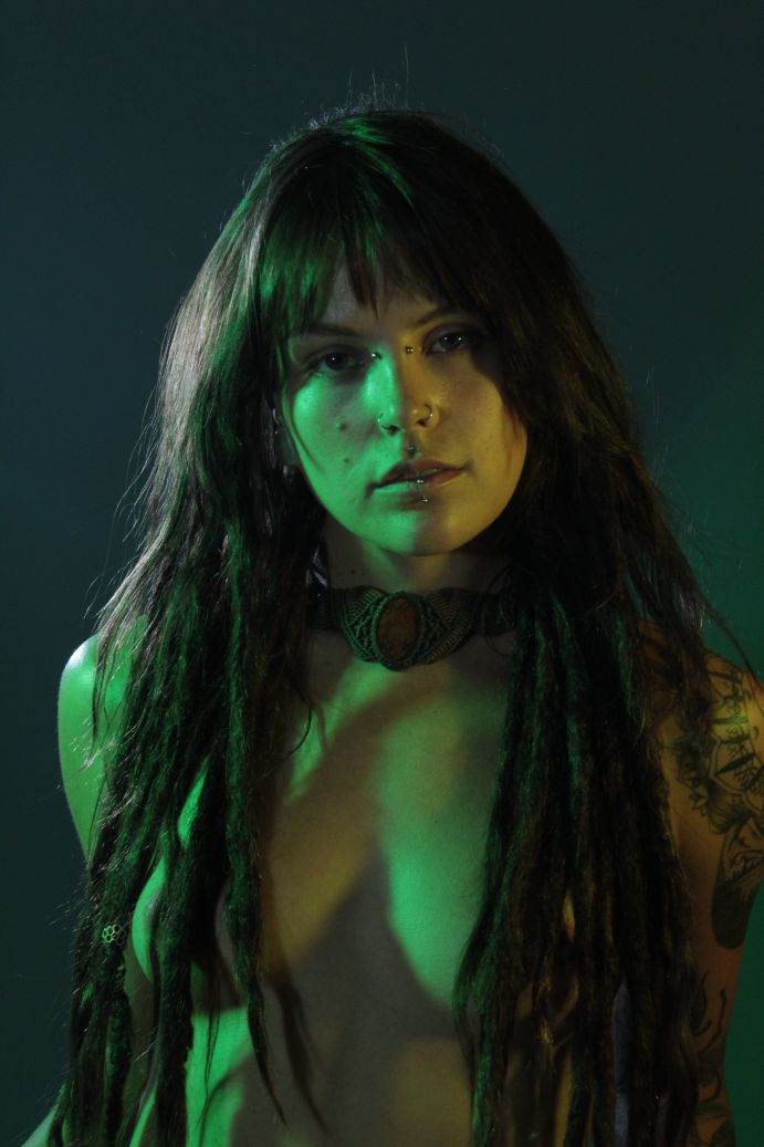 topless woman with green and yellow side lights with black background
