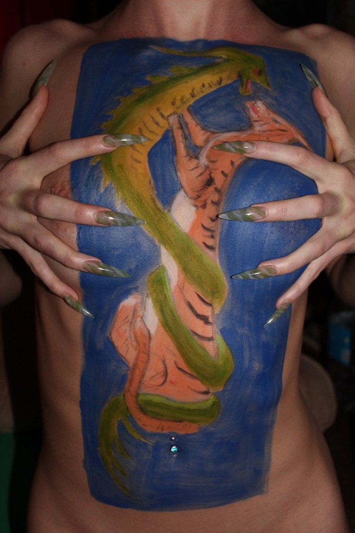 painting on female torso of tiger and dragon fighting