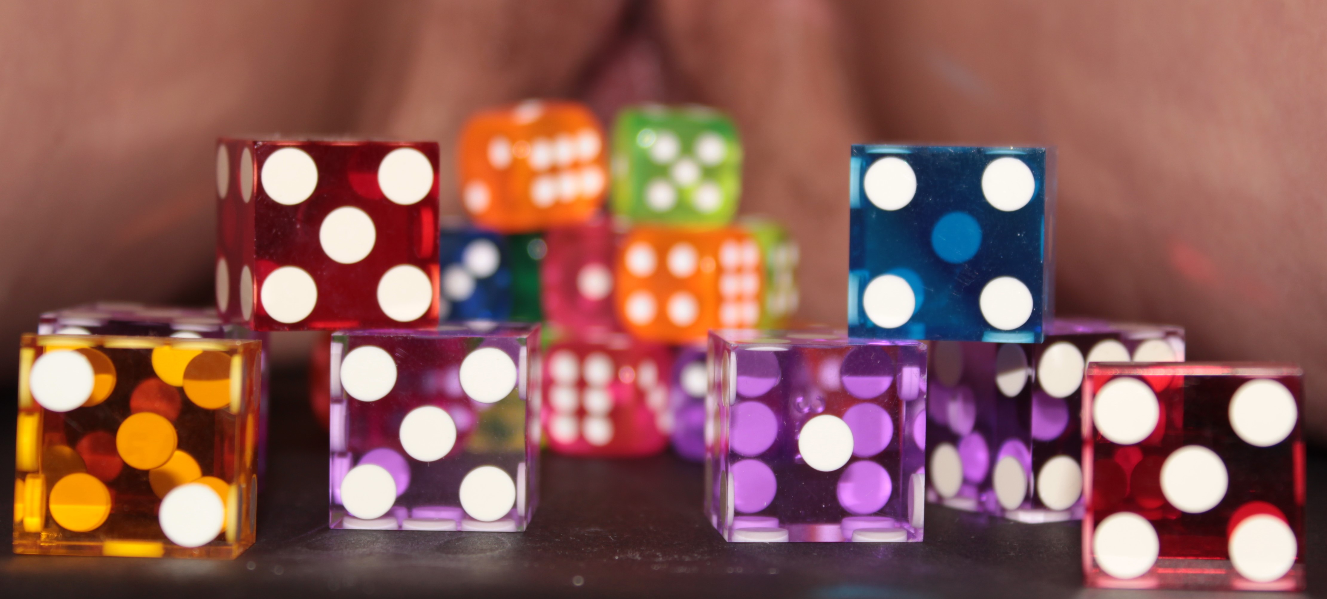 photo of colorful dice in front of open leg, exposed vulva