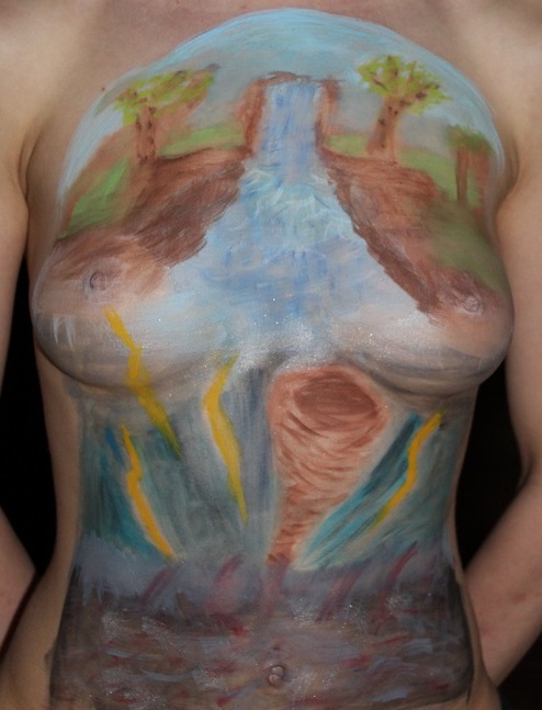 body painting on female torso. Top third: trees, river, waterfall. Middle third: tornado and lightning. Lower third: black stormy sea